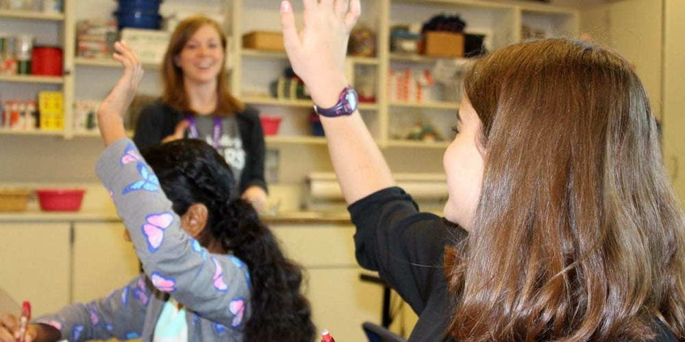 students raising hands