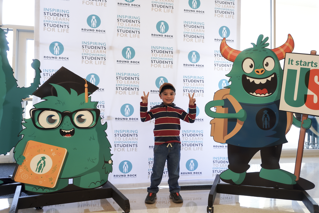 A student posing with cutouts