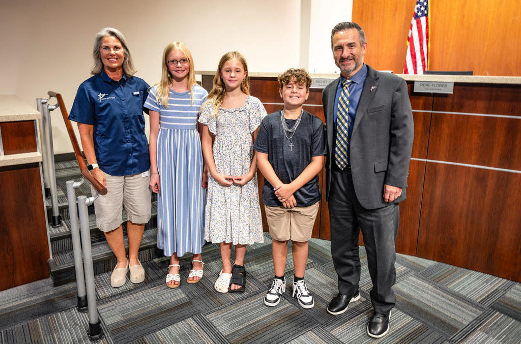 two adults and three children smiling
