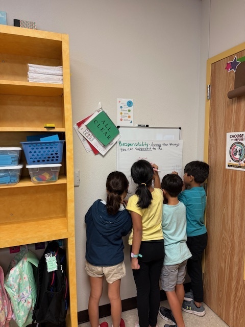 4 students writing on a chart