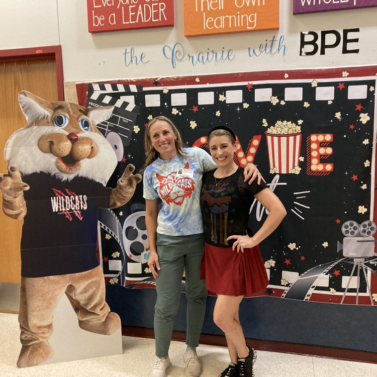 two women posing in front of a banner