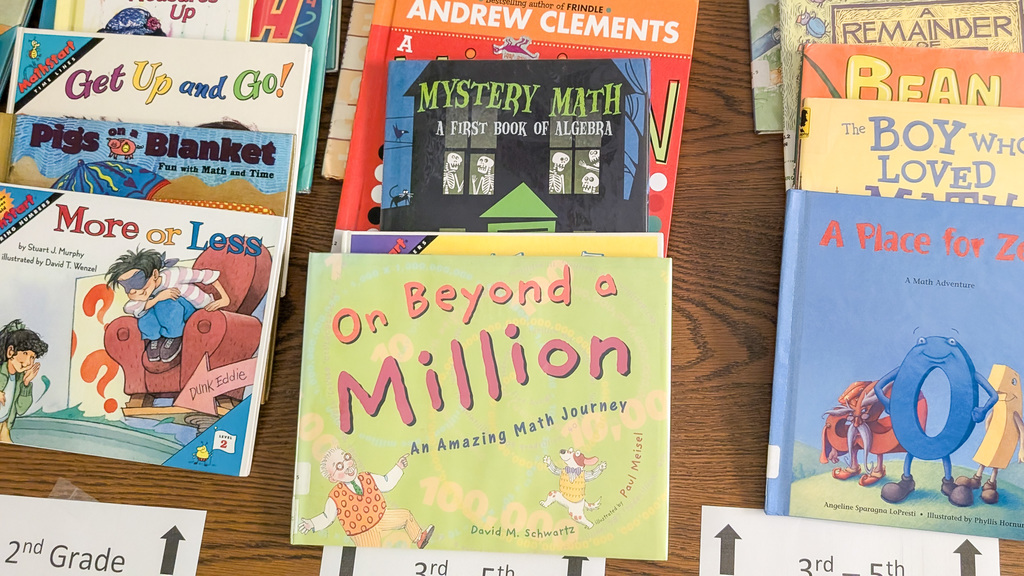 Staff and volunteers reading math books to young students at Jollyville Elementary School