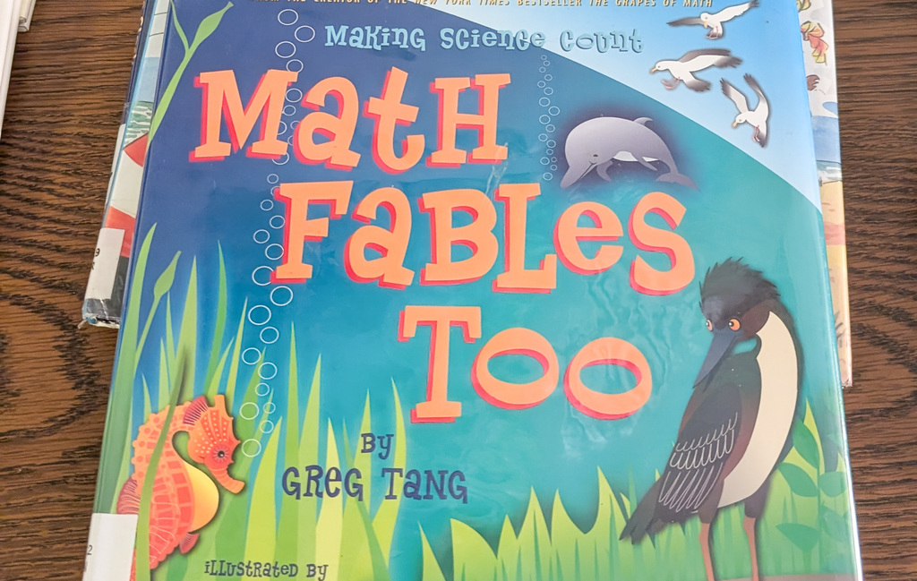 Staff and volunteers reading math books to young students at Jollyville Elementary School