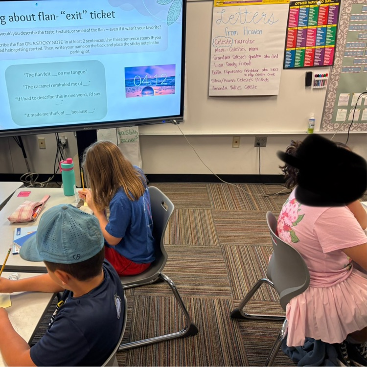 Elementary students sit at desks .