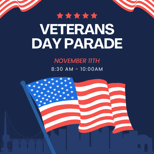 A graphic announcing a Veterans Day Parade on November 11th from 8:30 AM to 10:00 AM. The image has a dark blue background with an American flag and a city skyline.
