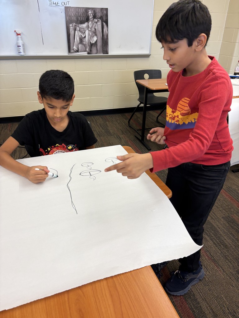 Two boys making a poster.