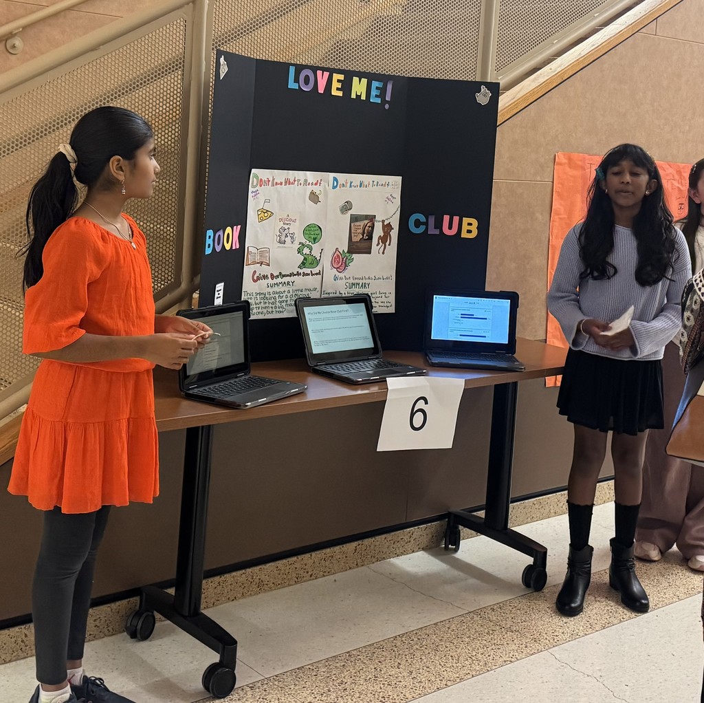 Students standing by chromebooks presenting