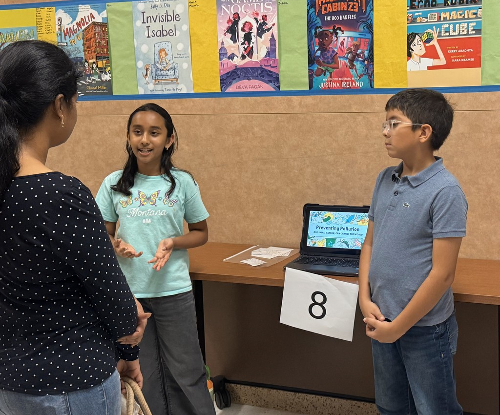 Students standing by chromebook presenting