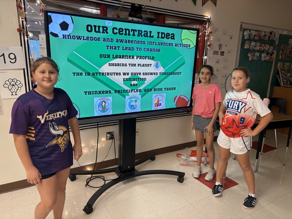 Students standing in front of big screen presenting