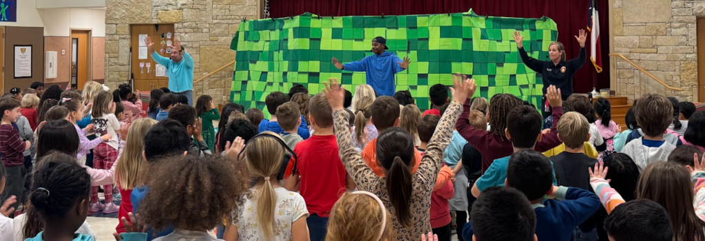 Three adults standing with their hands up in front of students