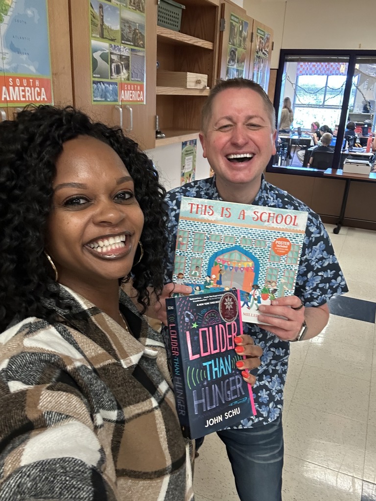 Author John Schu standing next to teacher holding books
