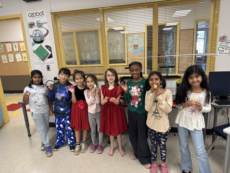 Girls standing with their designs. 