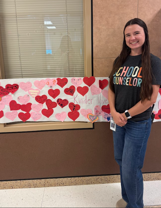 Counselor standing in front of window and wall and banner