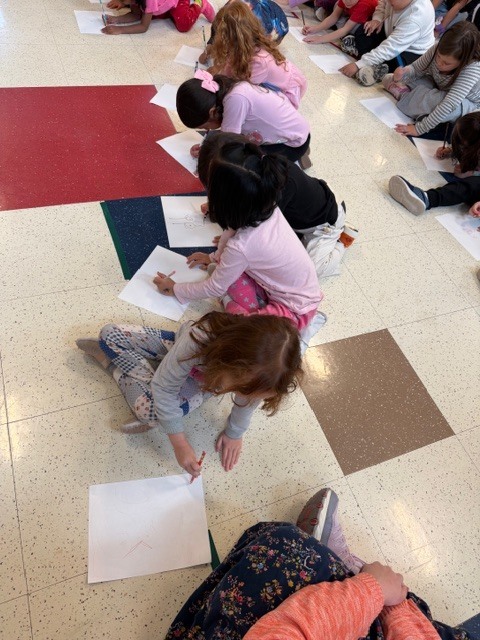 Students sitting on floor drawing