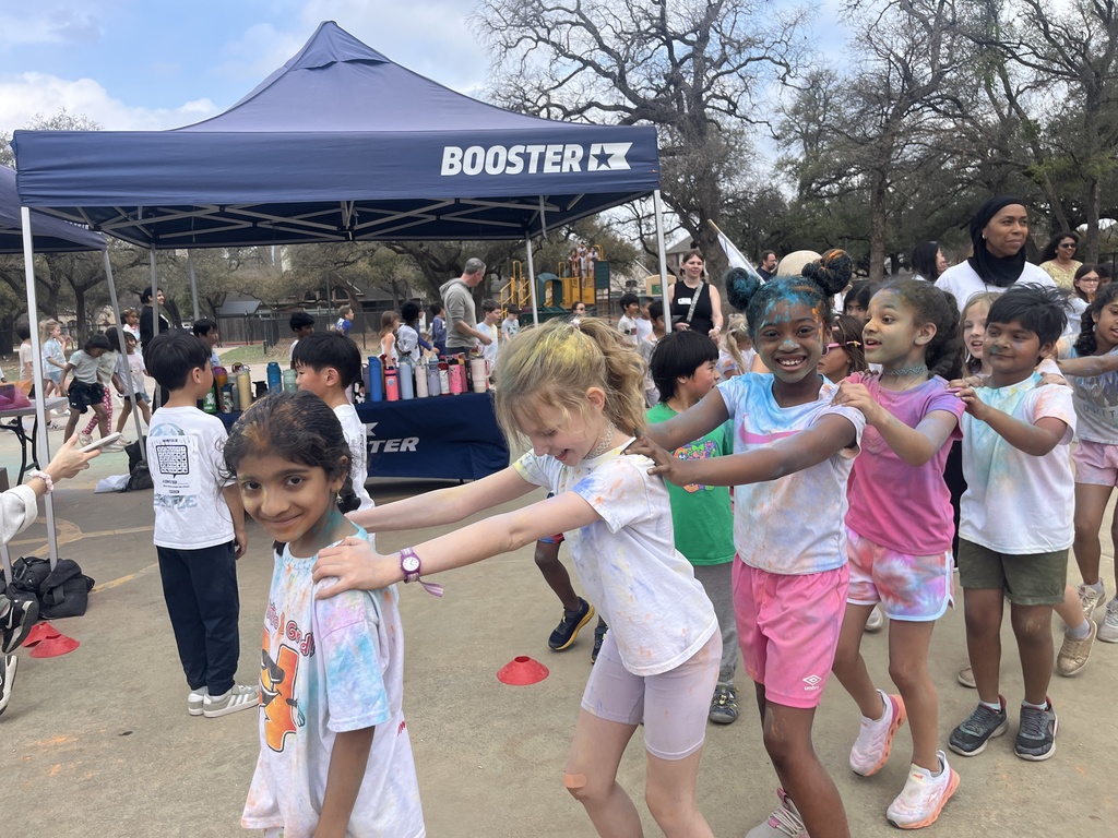 2nd graders covered in colors doing the conga dance