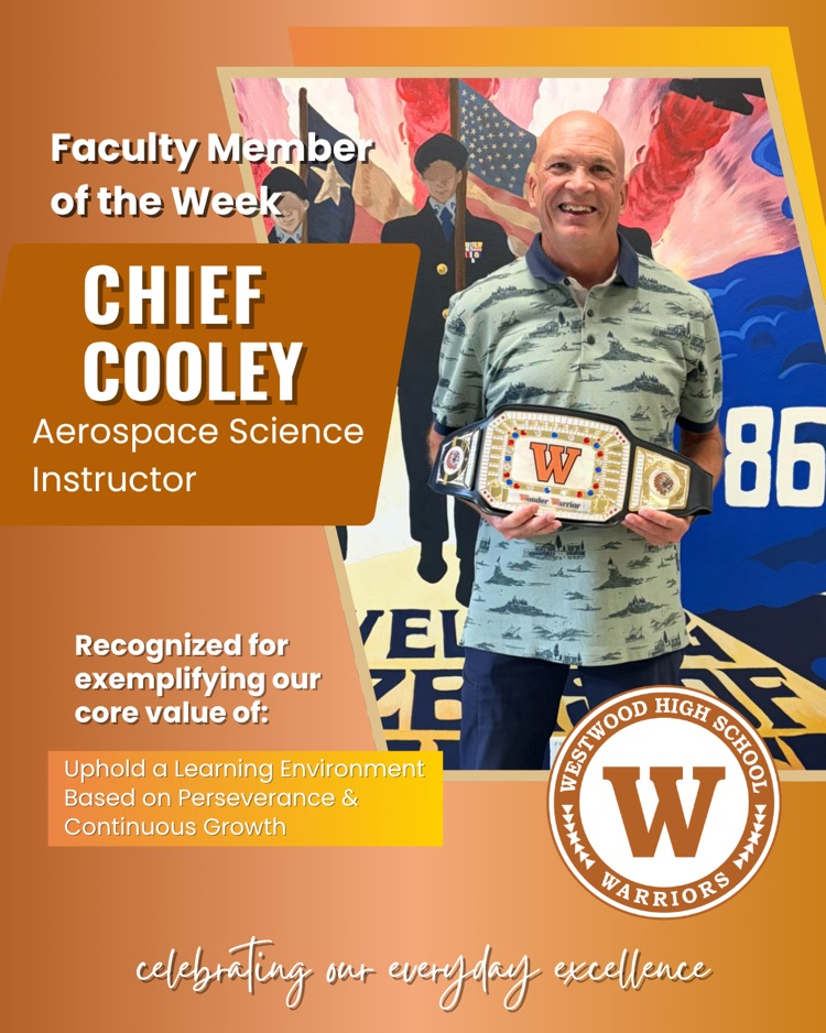 photo of teacher Chief Cooley smiling and holding the teacher of the week championship belt 