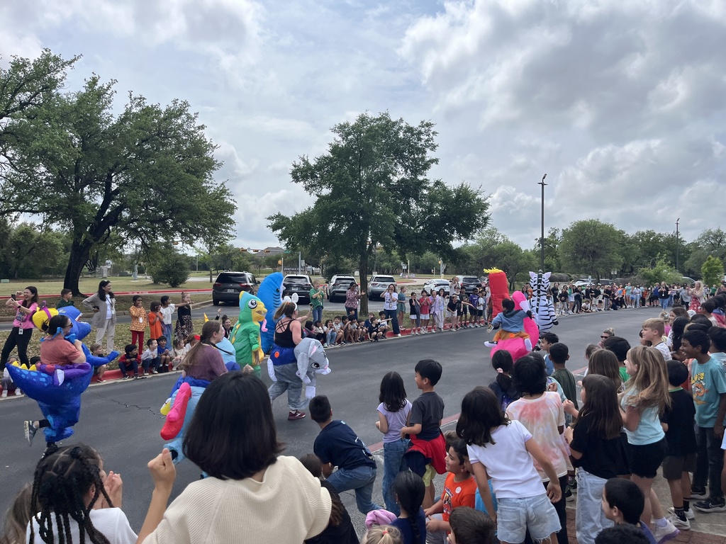 Students watching the inflatables running down the street. 