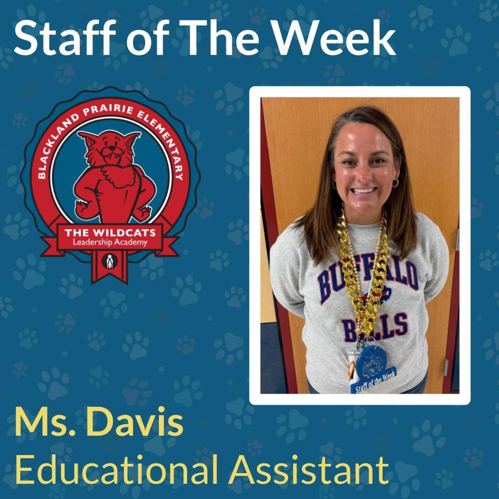 Photo of Ms. Davis, an Educational Assistant at Blackland Prairie Elementary, who is the Staff of the Week. She is smiling and wearing a Buffalo Bills sweatshirt and a gold Staff of the Week lanyard. The school mascot, a red wildcat, is pictured on the left.
