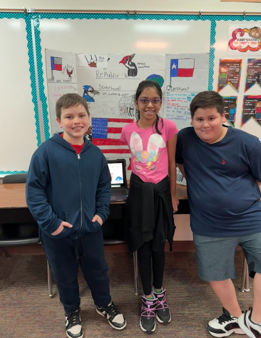 Three students standing in front of a chromebook and trifold board titled "Republic & Statehood"