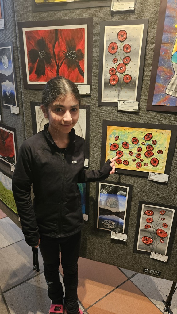 Student standing next to her artwork. 