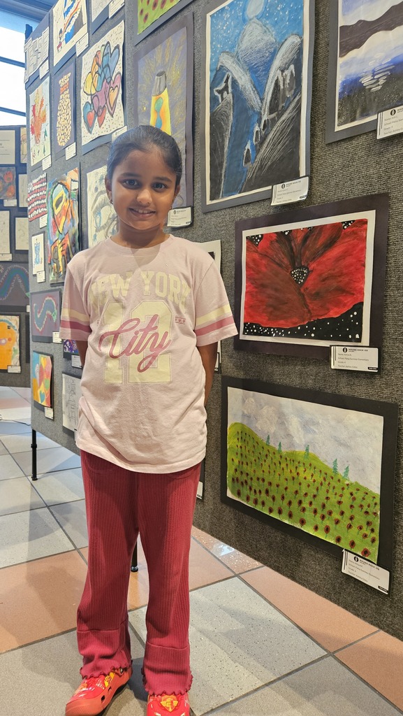 Student standing next to her artwork. 