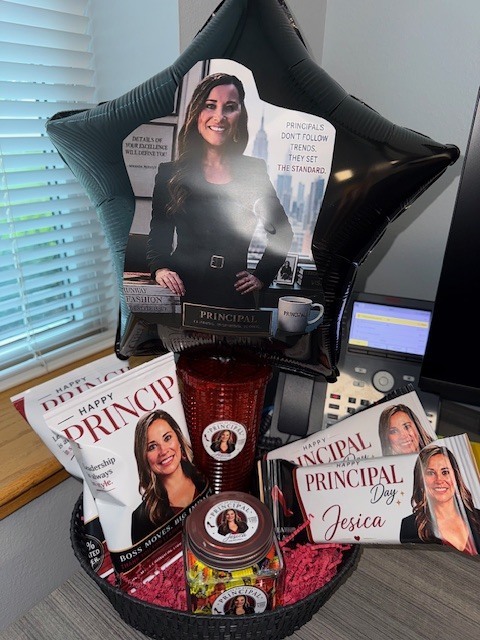 A gift basket for Principal Jesica featuring a star shaped balloon and custom snack bags with her photo. The items display phrases about leadership and setting the standard.