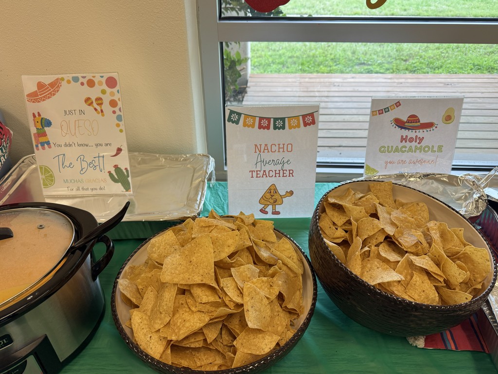 Two bowls of chips and crockpot with queso sitting on table with three signs that read: "Just in Questo you didnt' know.... you are the Best! Muchas Gracias for all that you do!",  "Nacho Average Teacher, and "Holy Guacamole you are awesome!