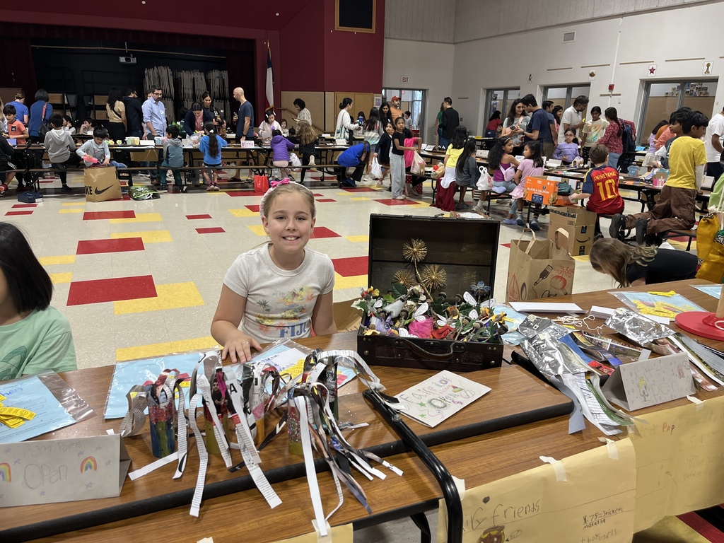 A student posing infront of her the products she made. 