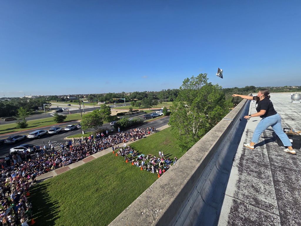 Ms. Elarms throwing a plan and it soaring in the sky. 