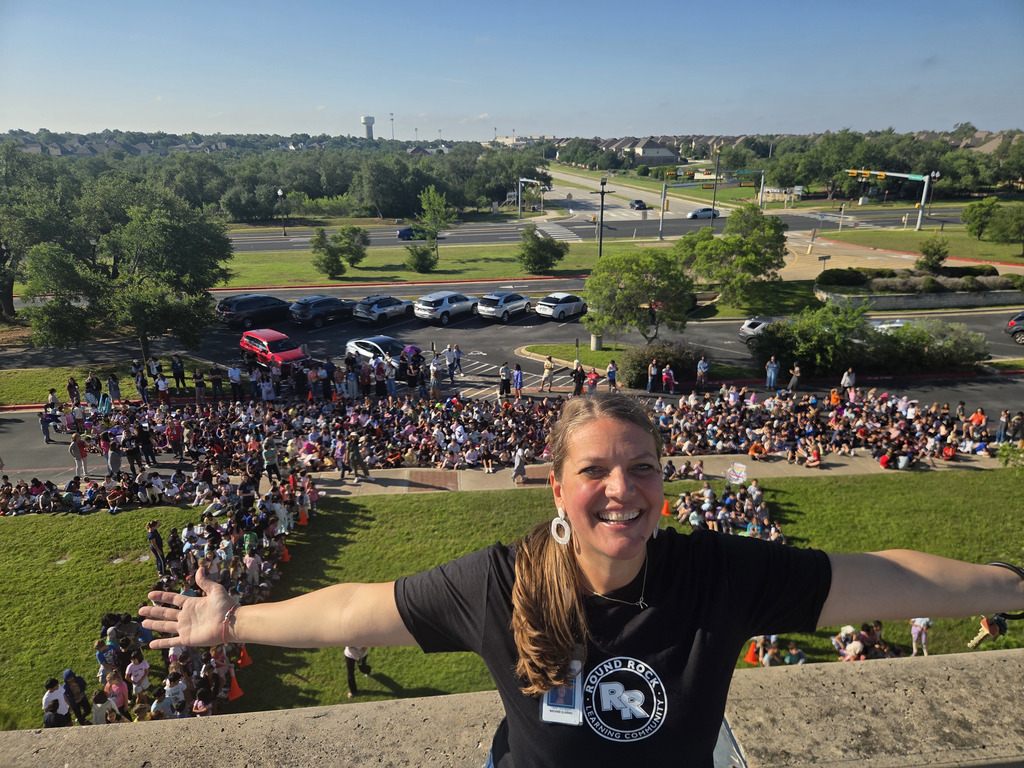 Principal Elarms on the roof with the student body behind her.