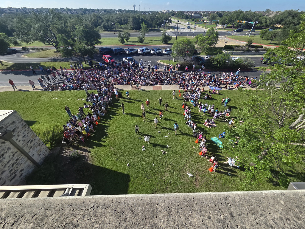 Bird's eye view of kids gathering their devices off of the ground. 