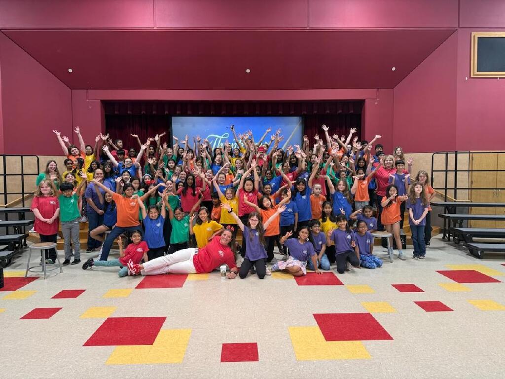 The principal is posing with the entire cast of performers. 