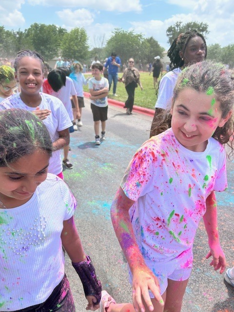 Students walking on the road covered in different colored dyes