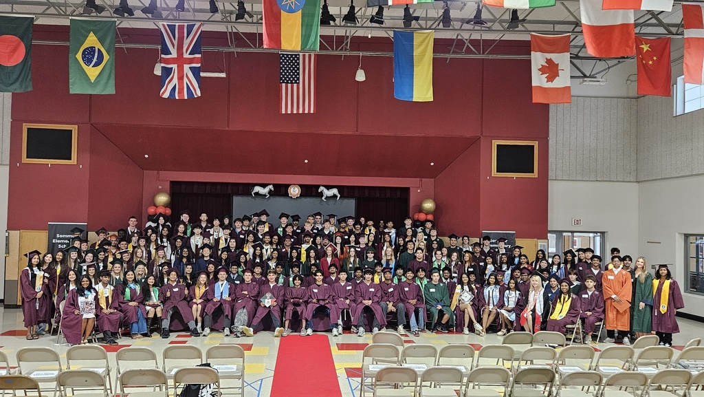 The entire class of graduation seniors in the school cafeteria for a group photo.