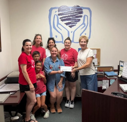 A picture of the team handing a check to a member of the center.