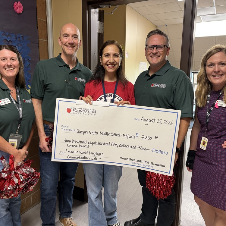 Ms Cuevas holding her check with Pie Foundation representatives. 