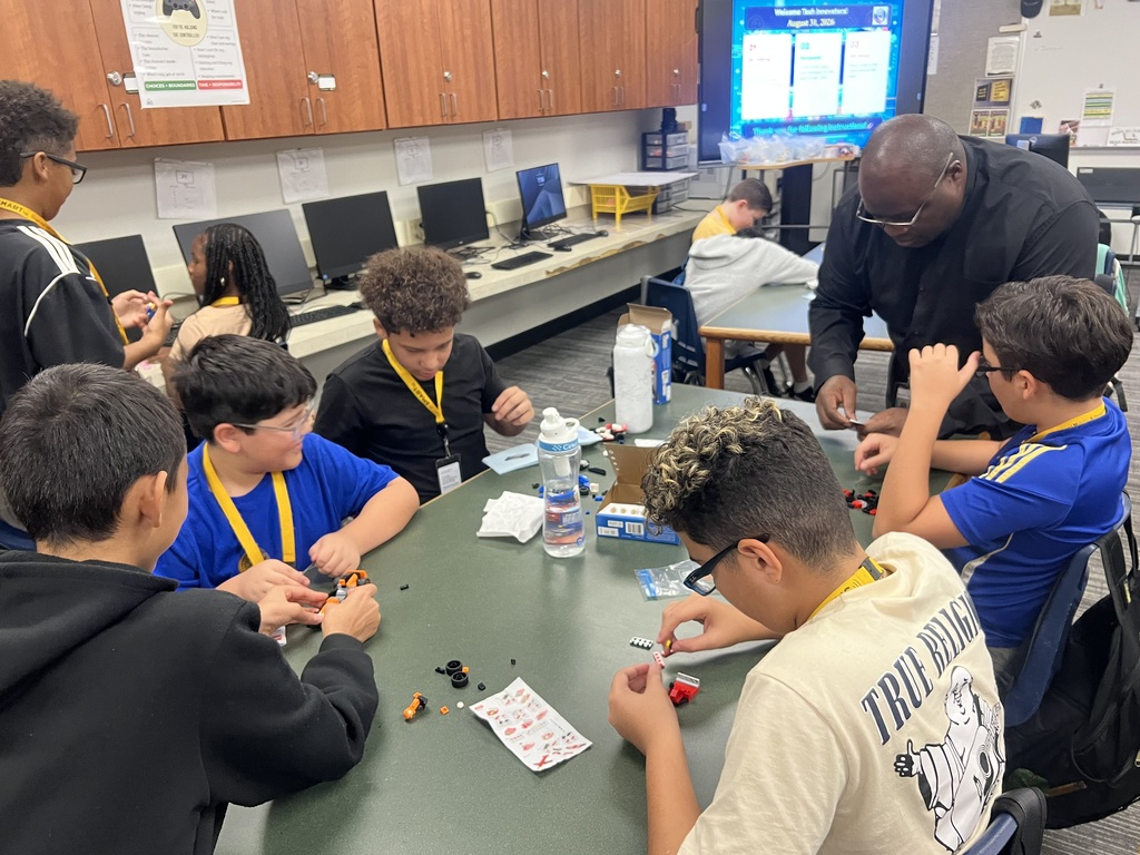Photo of students and teacher working with LEGOs