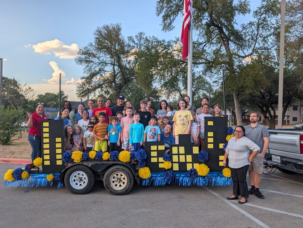 Picture of students and families on a superhero themed parade float