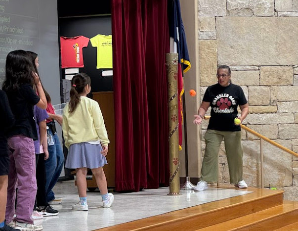 Students are facing a teacher. A student had just bounced an orange ball at a teacher for the impossible shot