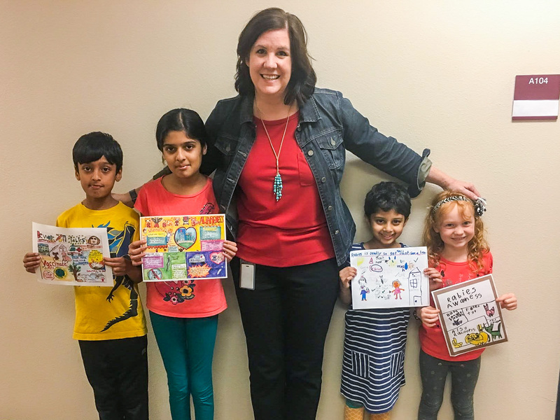 Vicki Crain with students showing artwork