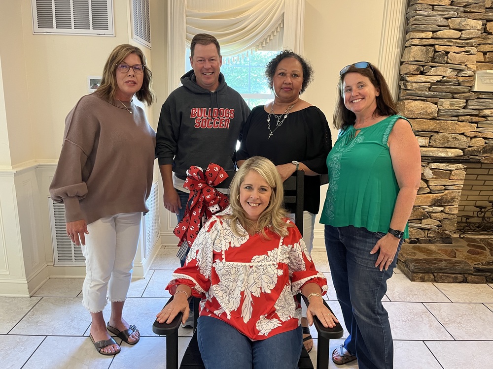 Pictured Left to right, Holly Oliver, Tim Ess, Christa Jones, and Judy Clayton, with Jennifer Carter sitting in a black rocking chair in front of them.