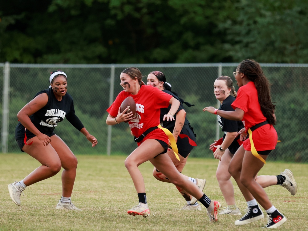 A group of girls playing flag football.