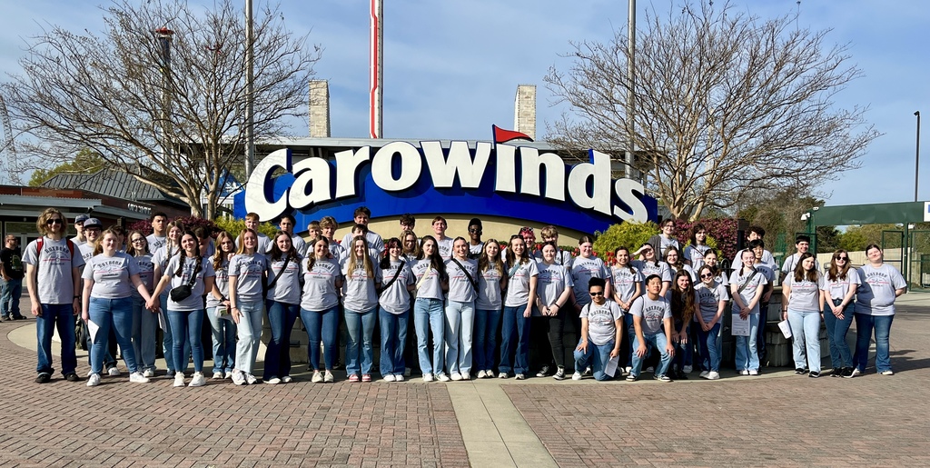 RCS High School Band students stand in front of the Carowinds sign.