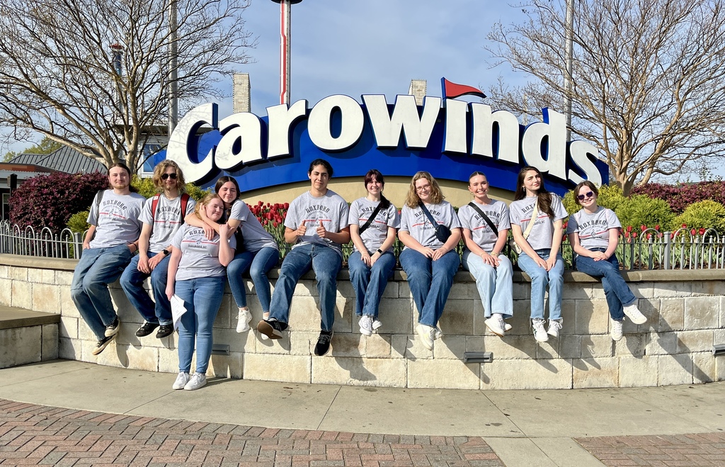 RCS High school band seniors pose in front of the Carowinds sign.