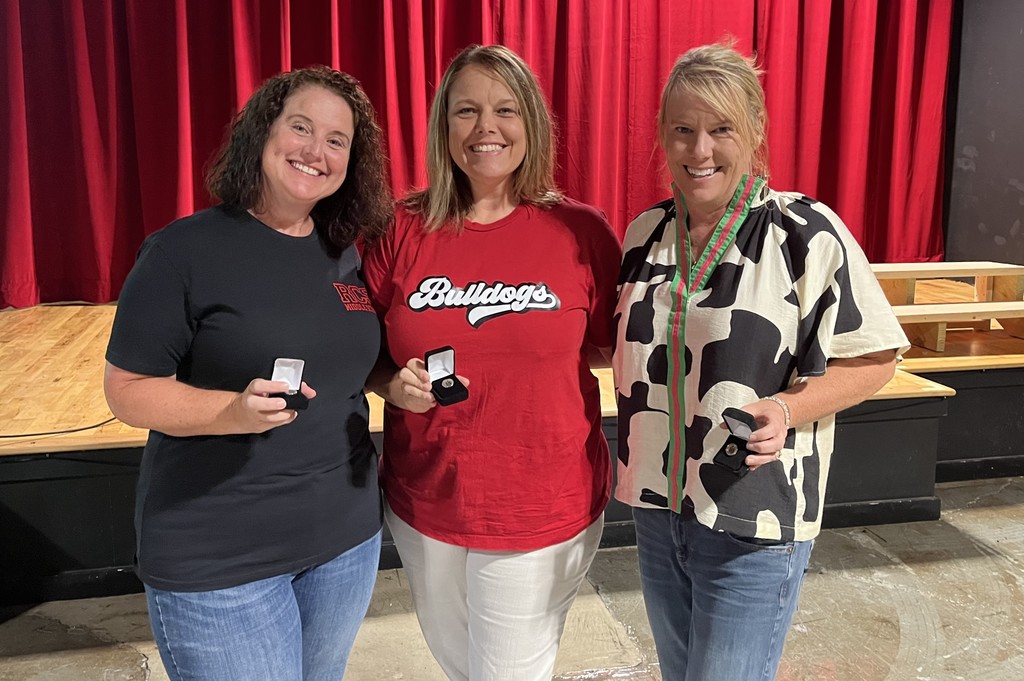Judith Clayton, Teresa Coleman, and Carrie Hawkins posing together holding pins celebrating 10 or 15 years of service at RCS