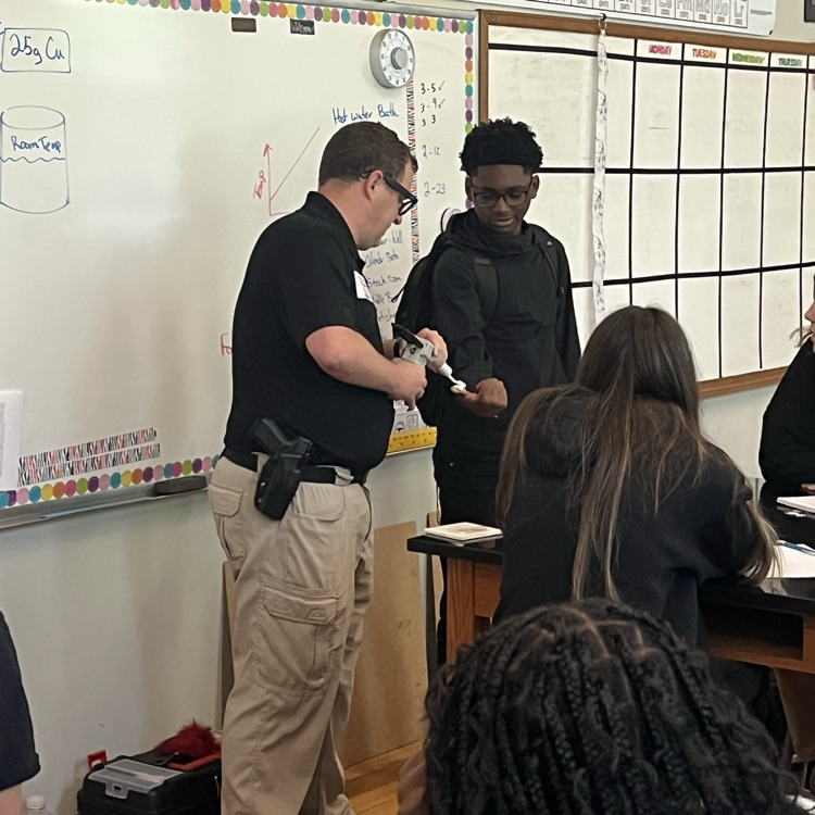 A man puts a white putty on a young man’s finger to take a mold of his finger to get a finger print.