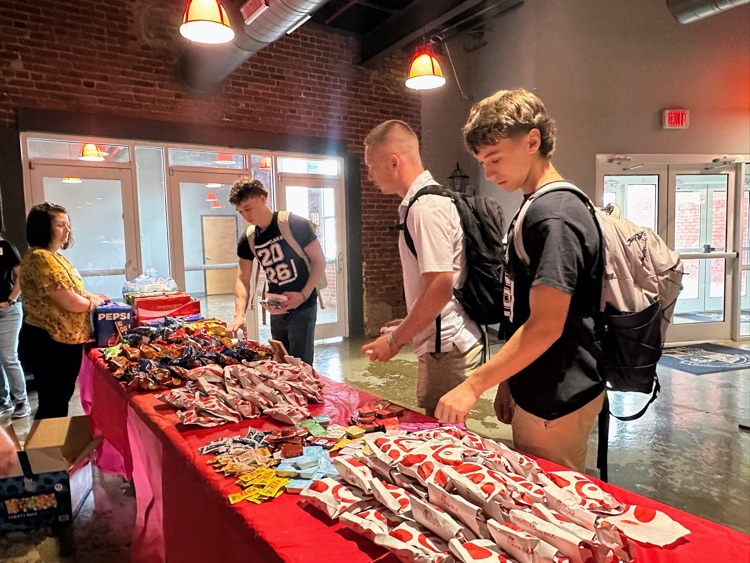students picking up a Chick-fil-A sandwich off a table