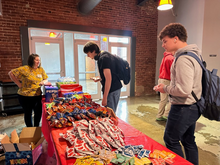 students waiting to get their lunch or Chick-fil-A sandwiches and chips from a table