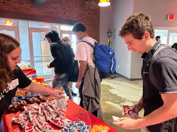 Students picking up Chick-fil-A sandwiches and chips from a table