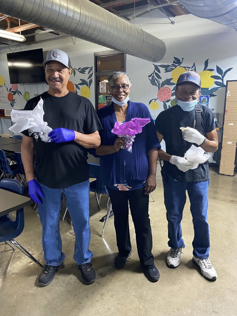 Mr. Rogers, Mrs. Angie, and Mr. Coy smiling with small gifts in their hands.